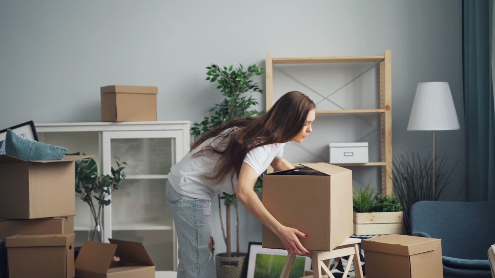 A mover carefully unpacking a labeled box in a San Francisco living room